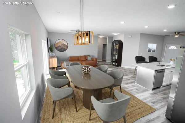 a living room with couches a dining table and chairs with wooden floor