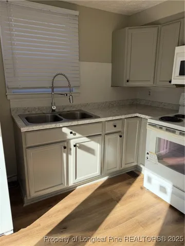 a kitchen with stainless steel appliances granite countertop a sink a stove and cabinets