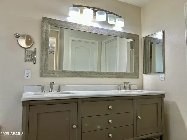 a bathroom with a sink and two mirror