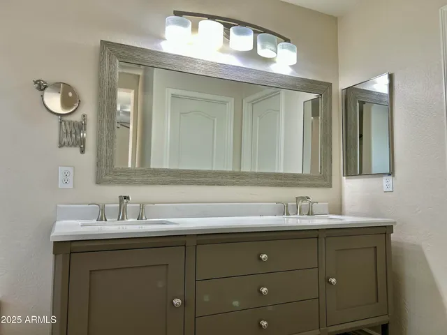 a bathroom with a sink and two mirror