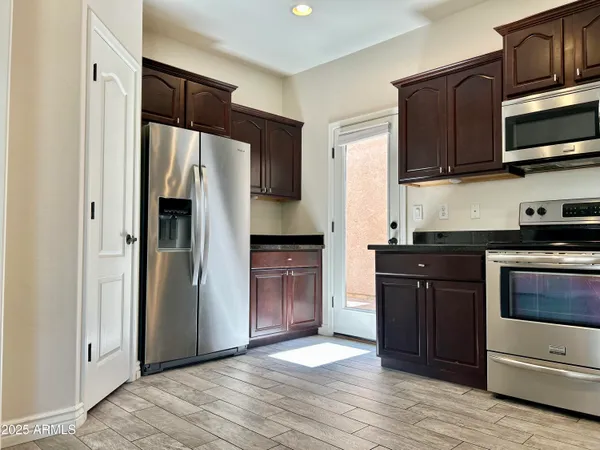 a kitchen with stainless steel appliances granite countertop a refrigerator and a stove top oven
