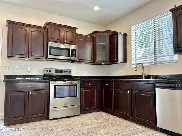 a kitchen with stainless steel appliances granite countertop a stove microwave and sink