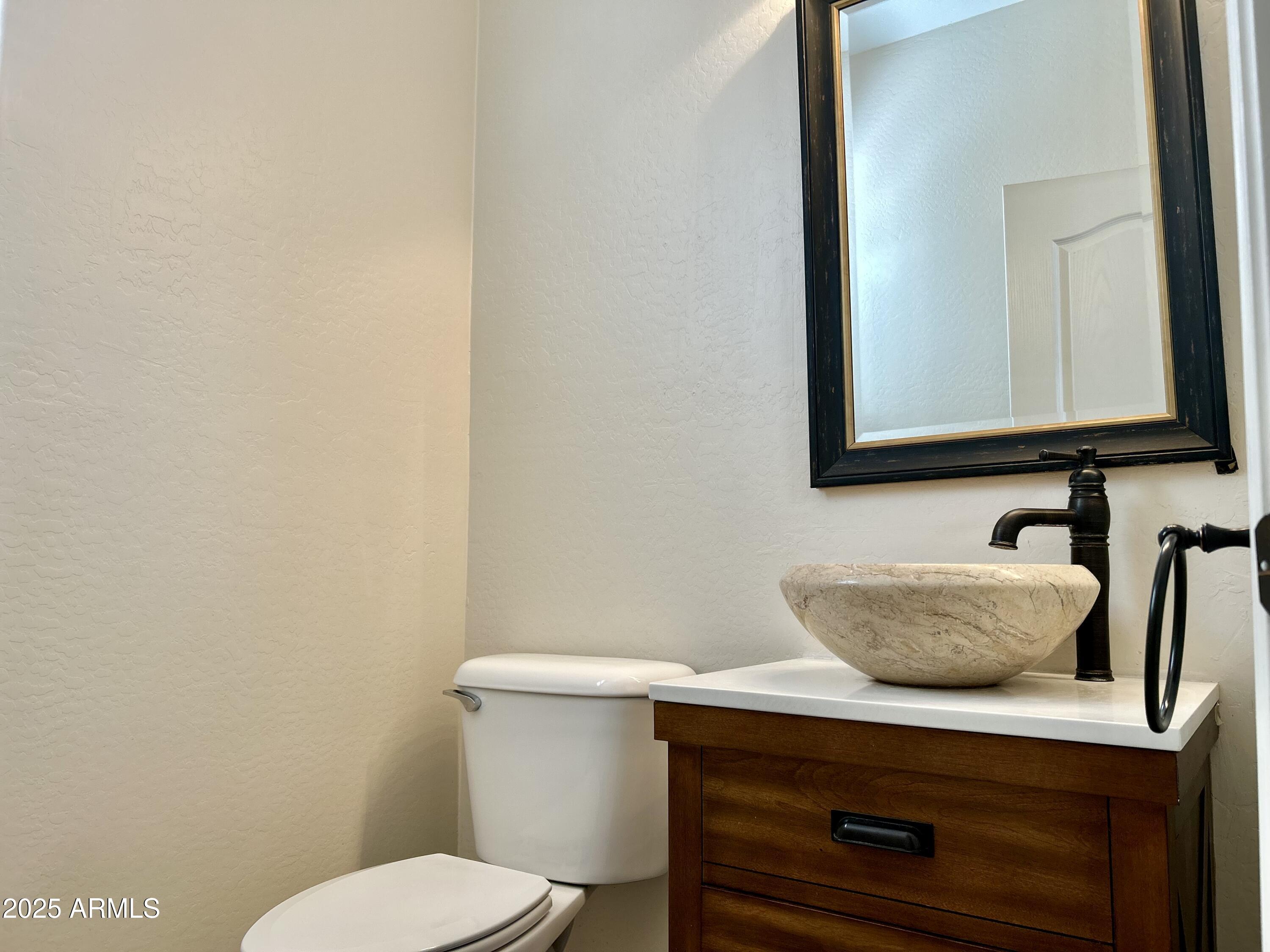 3853 East Santa Fe Lane Gilbert, AZ 85297 - Photo 8 of 23 a bathroom with a toilet a sink and mirror