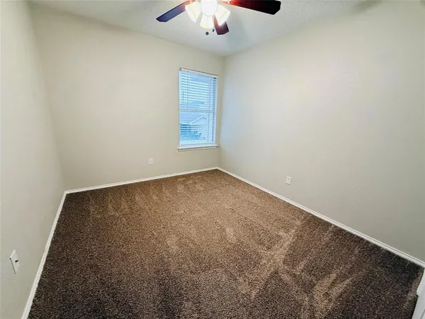 an empty room with a chandelier fan