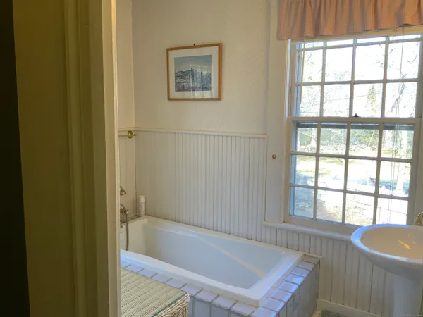 a bathroom with a tub and large window