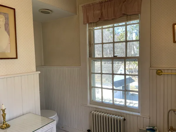 a bathroom with a toilet a sink and a window