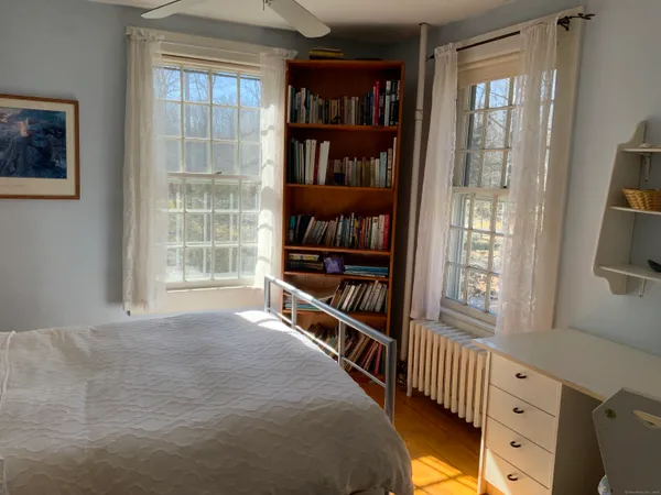 a view of a bedroom with wooden floor and balcony