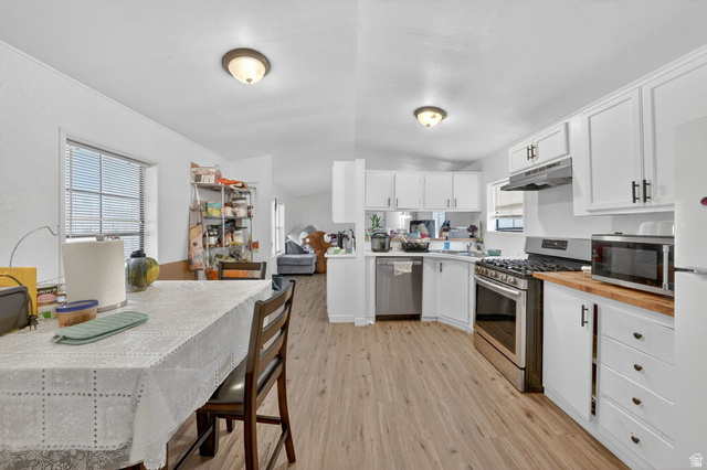 262 Hidden View Drive, Unit 94 Sandy, UT 84070 - Photo 12 of 18 Kitchen with stainless steel appliances, butcher block counters, white cabinetry, vaulted ceiling, and light wood-type flooring