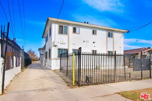 a view of a white house with iron fence