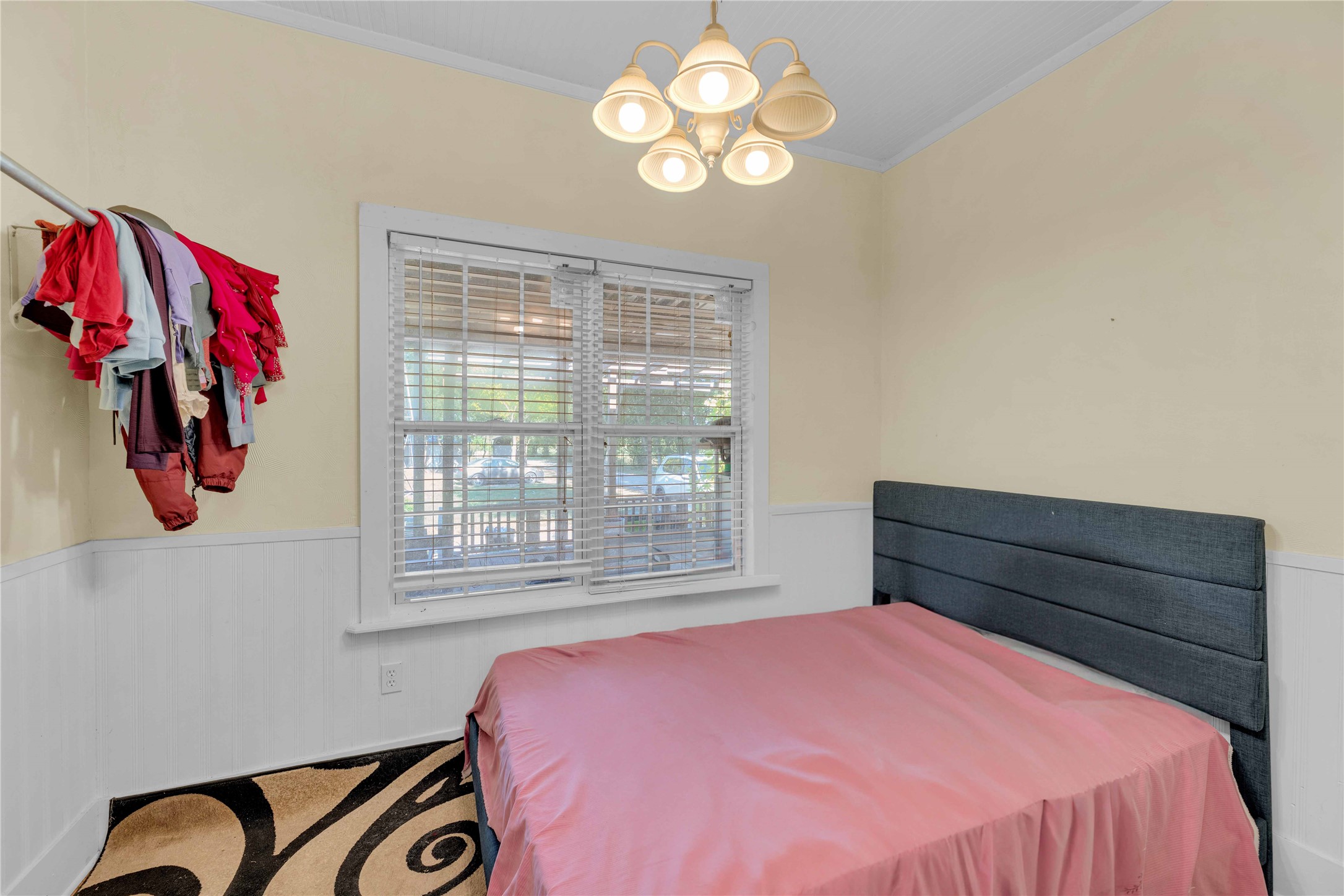 20235 Engelmann Lane Manor, TX 78653 - Photo 28 of 34 Bedroom with wainscoting, crown molding, a chandelier, and carpet flooring