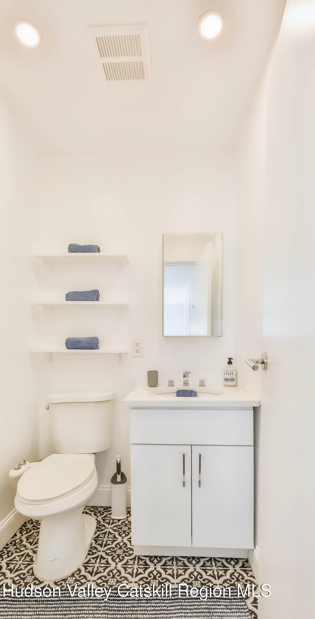 59 Scribner Hollow Road, Unit B2 Hunter, NY 12442 - Photo 21 of 42 a bathroom with a sink a toilet and mirror