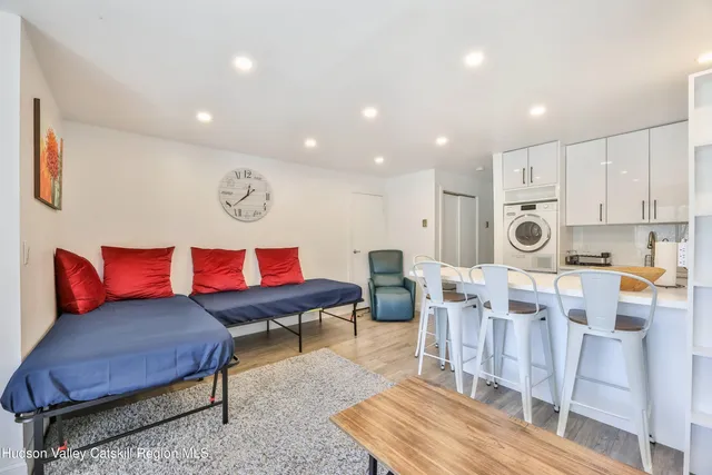 a living room with furniture a flat screen tv and a table