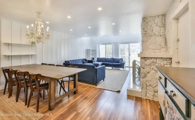a view of a dining room with furniture a chandelier and wooden floor