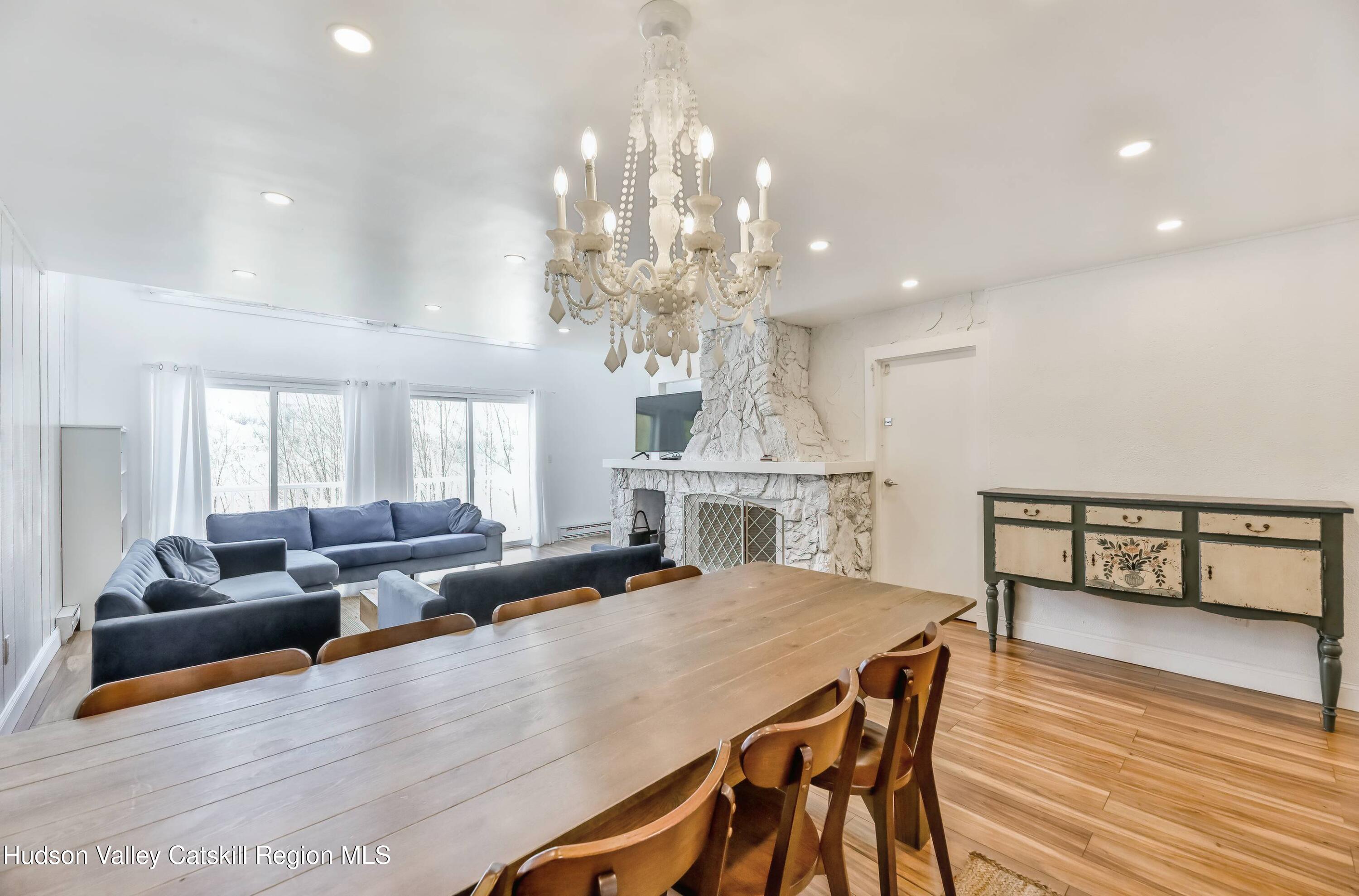 59 Scribner Hollow Road, Unit B2 Hunter, NY 12442 - Photo 8 of 42 a view of a dining room with furniture a chandelier and wooden floor