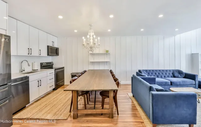 a kitchen with kitchen island a stove a table and chairs in it