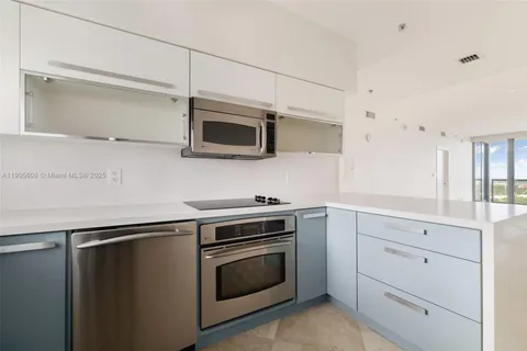 a kitchen with stainless steel appliances white cabinets and a stove top oven