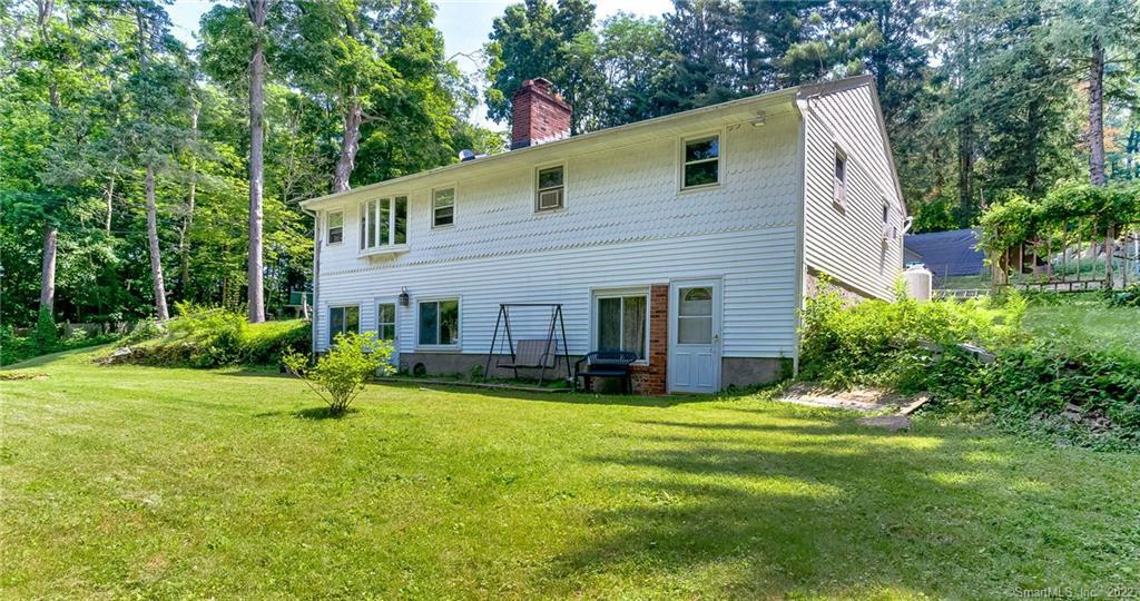 a view of a house with a yard and sitting area