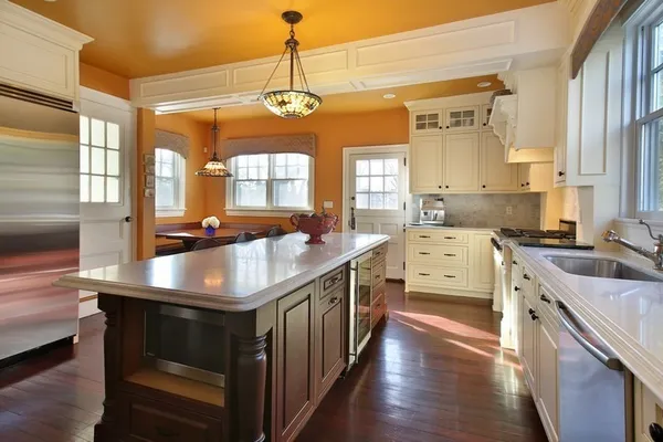 a kitchen with stainless steel appliances granite countertop a stove a sink dishwasher and microwave with wooden floor