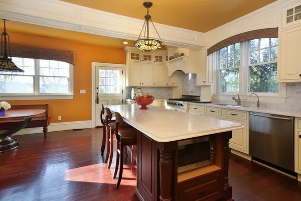 a kitchen with a sink a stove a dining table and chairs