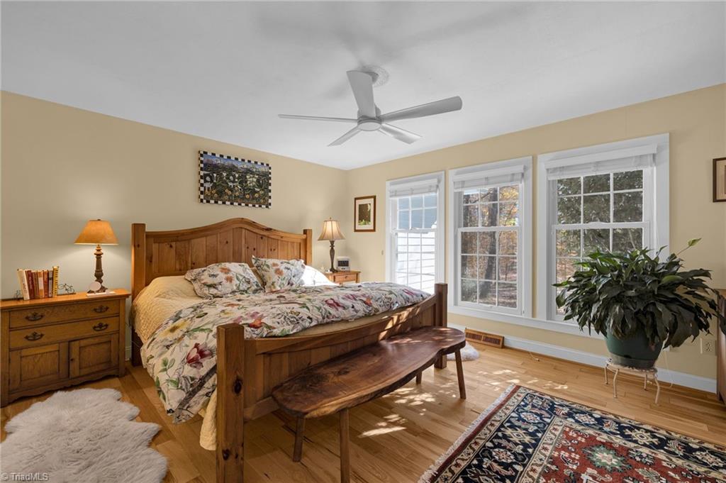 4300 Williams Road Lewisville, NC 27023 - Photo 16 of 50 Primary bedroom, wood floors, tons of windows.