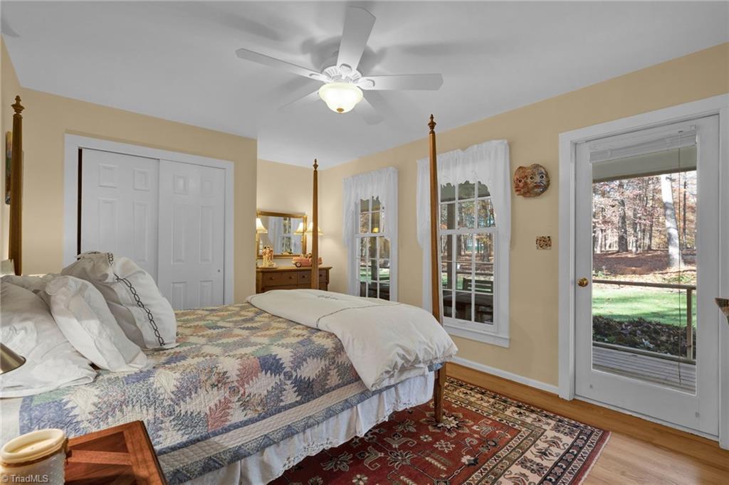 4300 Williams Road Lewisville, NC 27023 - Photo 23 of 50 Secondary bedroom with wood floors and door to screen porch