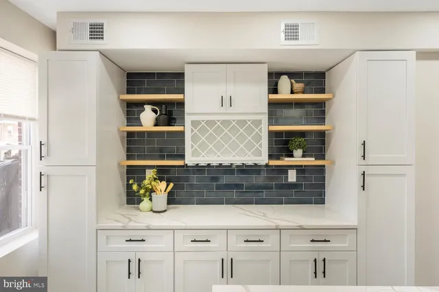 a kitchen with white cabinets and appliances