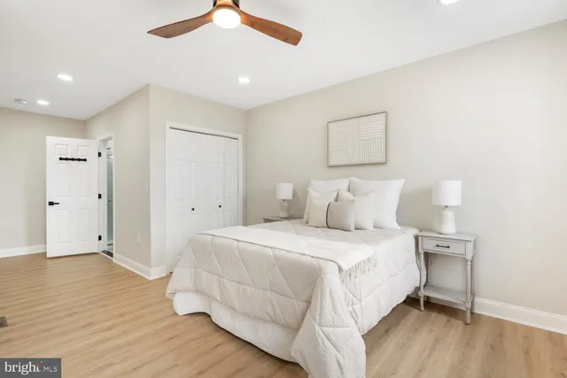 a bedroom with a bed and a ceiling fan