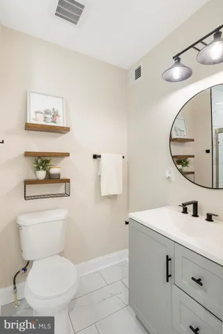 a bathroom with a toilet sink and mirror