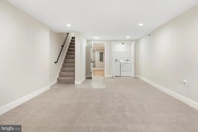 a view of an empty room with stairs and a ceiling fan