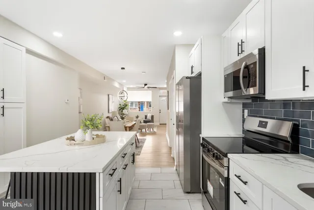 a kitchen with a sink a stove and chairs