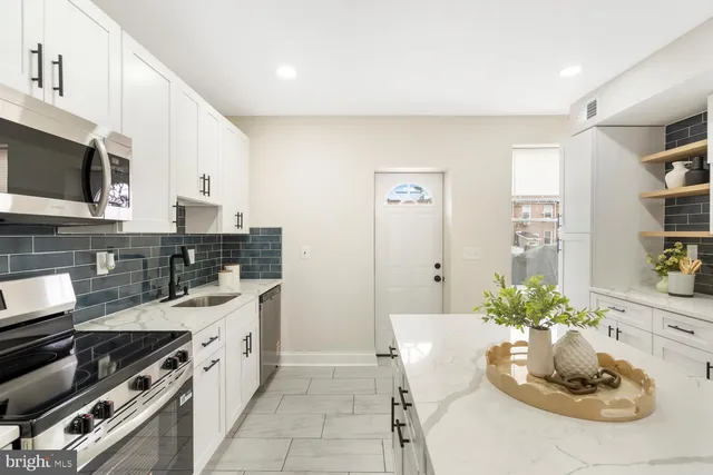 a kitchen with stainless steel appliances kitchen island granite countertop a sink and cabinets