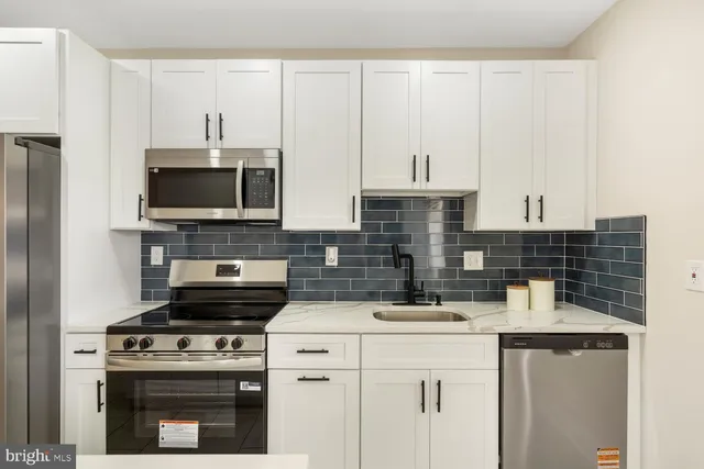 a kitchen with stainless steel appliances a stove a sink and a microwave