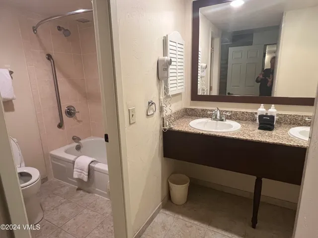 a en suite bathroom with a granite countertop sink and a mirror