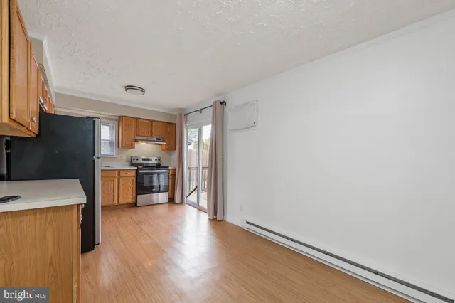 a kitchen with granite countertop a stove a sink and a refrigerator