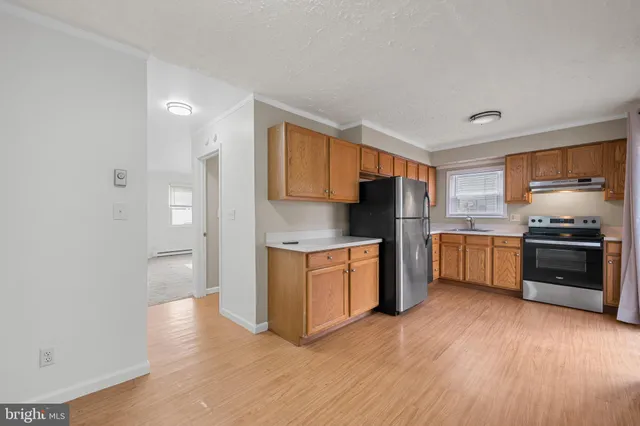 a kitchen with granite countertop a refrigerator and a stove top oven