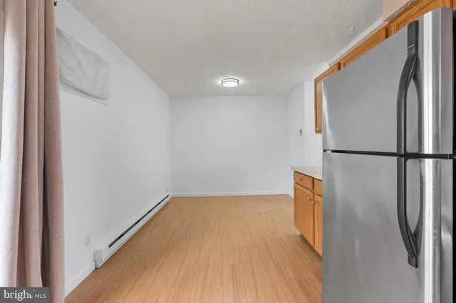 a view of a room with wooden floor and a hallway