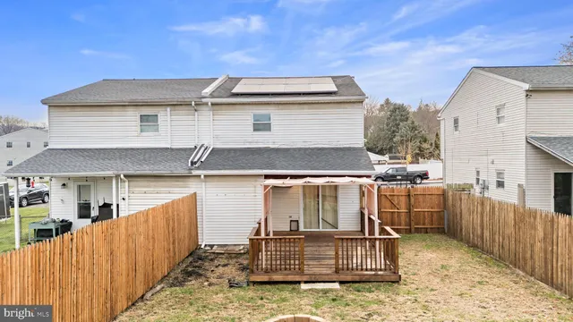 a view of a white house with wooden fence