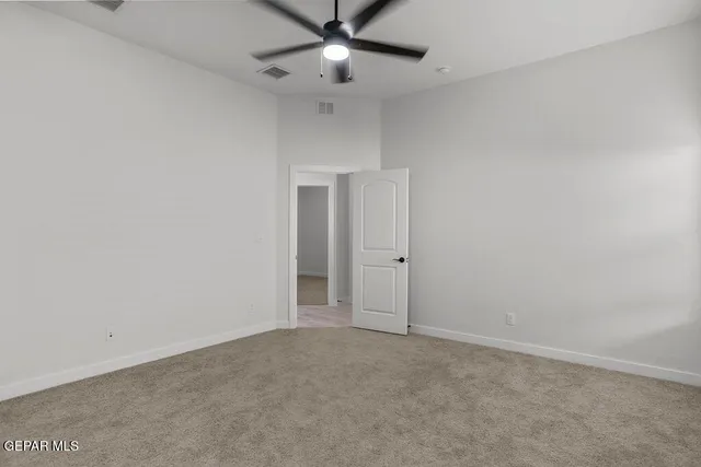 an empty room with closet and a chandelier fan