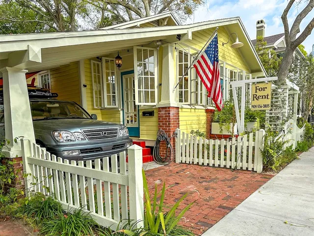 a view of a house with wooden deck and furniture