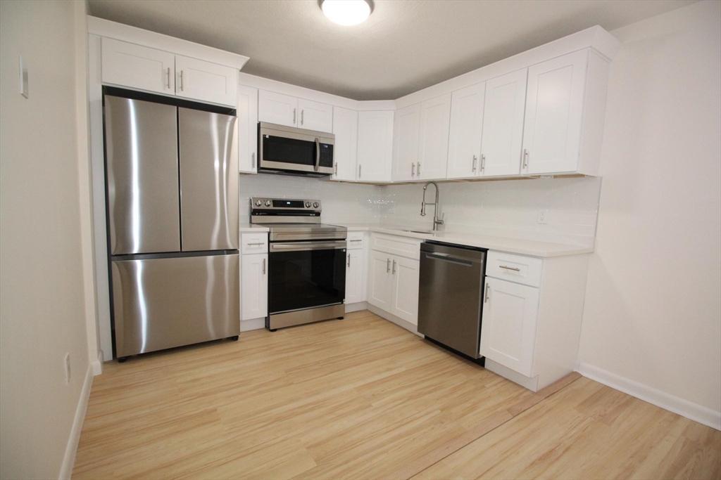 a kitchen with stainless steel appliances granite countertop a refrigerator microwave and sink