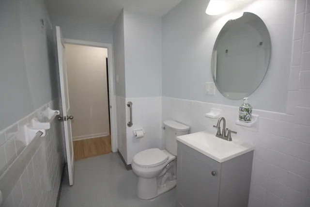 a bathroom with a toilet sink and mirror