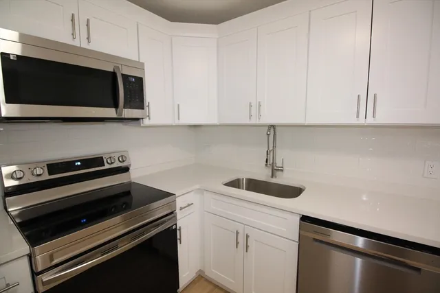 a kitchen with a sink and white cabinets