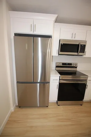 a kitchen with a refrigerator stove and microwave