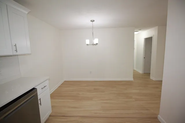 a view of a room with wooden floor and white walls