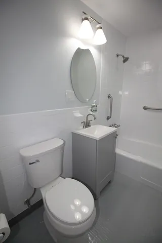 a bathroom with a toilet a sink and mirror