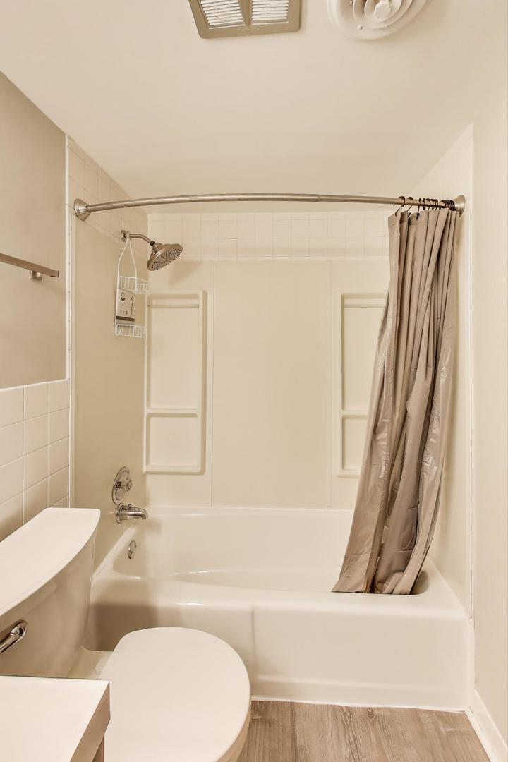 3838 West 111th Street, Unit 209 Chicago, IL 60655 - Photo 11 of 16 a bathroom with a tub a sink and a toilet