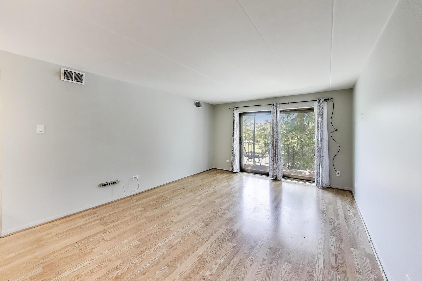 3838 West 111th Street, Unit 209 Chicago, IL 60655 - Photo 5 of 16 wooden floor in an empty room with a window