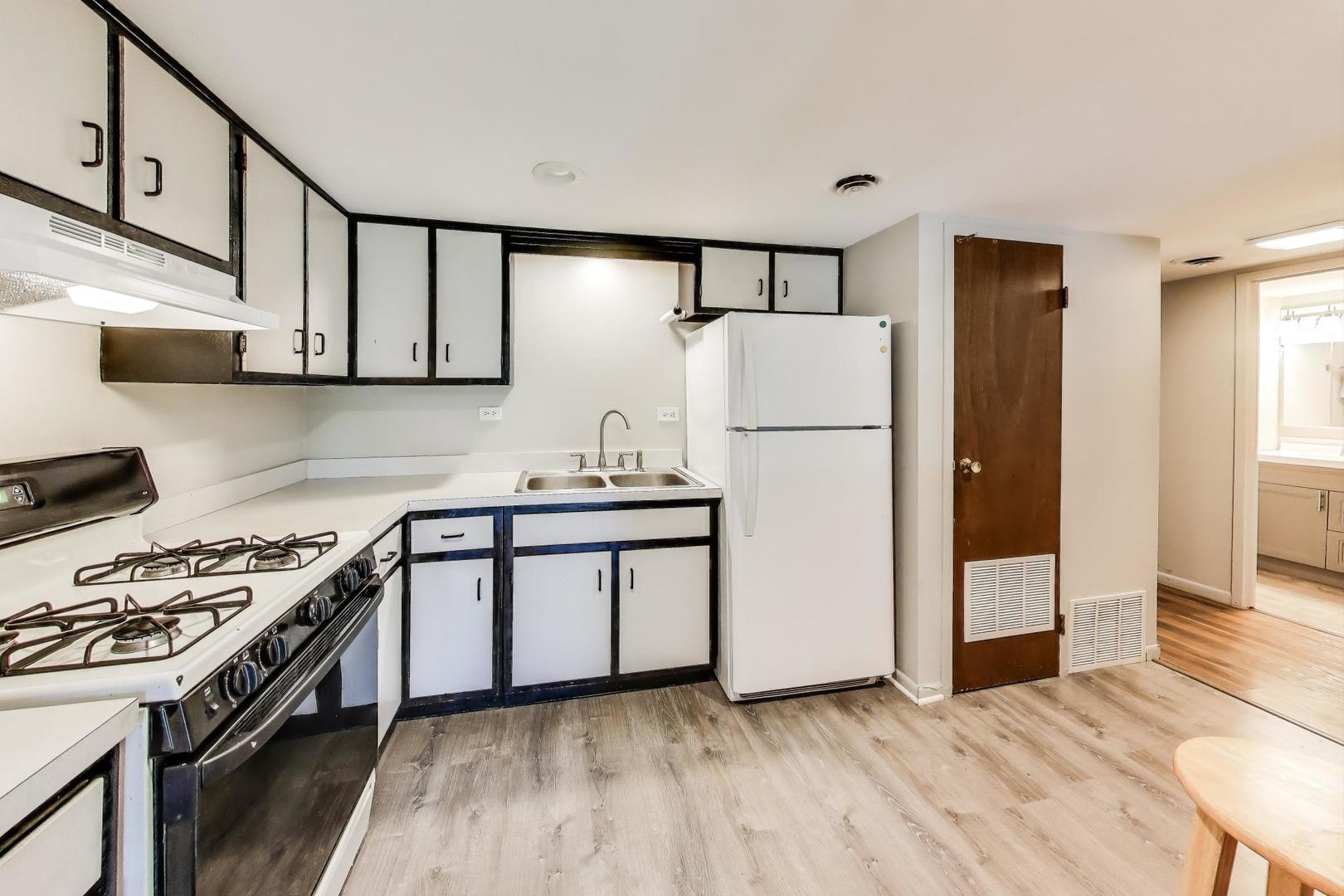 3838 West 111th Street, Unit 209 Chicago, IL 60655 - Photo 7 of 16 a kitchen with stainless steel appliances a refrigerator a sink and white cabinets