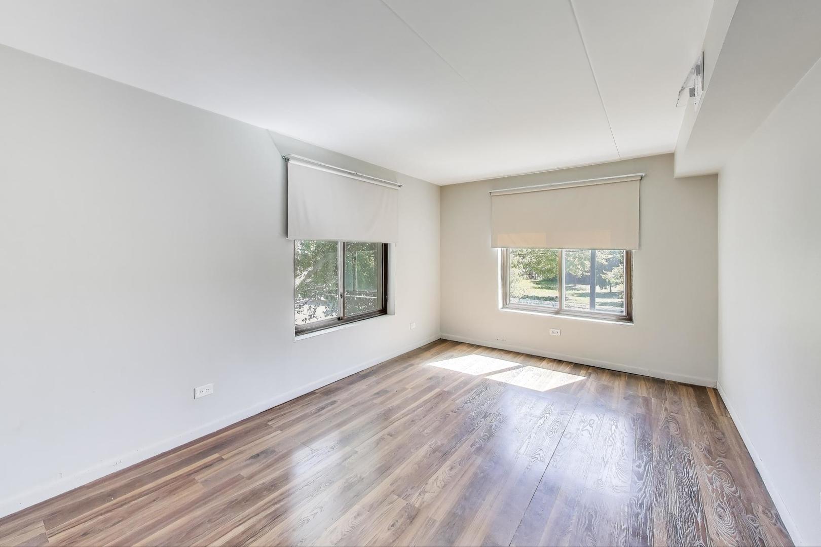 3838 West 111th Street, Unit 209 Chicago, IL 60655 - Photo 9 of 16 an empty room with wooden floor and windows