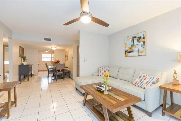 a living room with furniture a dining table and a piano